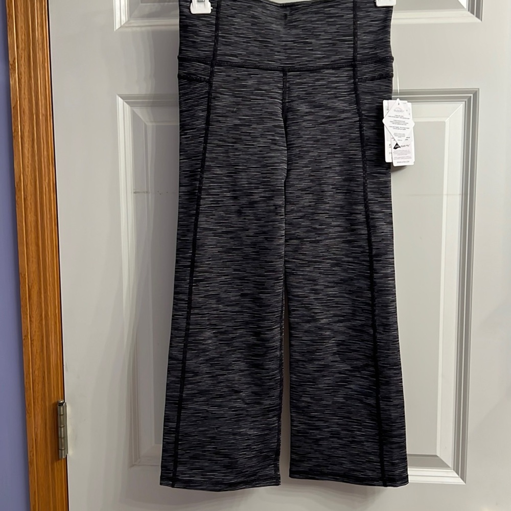 Capri length leggings. Brand new! Cute flare with slit in the back.  Fine stripe